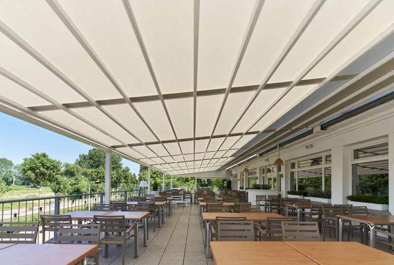 Reference picture of a pergola stretch with white frame and cream fabric cover on the roof terrace of the "bootshaus" in Mannheim, Germany